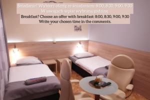 格丁尼亚Biały Słoń的有两张床、一张桌子和几把椅子的房间