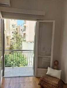 a room with a door open to a balcony at Ήσυχο φωτεινό δωμάτιο με βεράντα in Athens