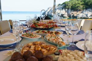 une table avec des assiettes de nourriture et des verres de vin dans l'établissement Lüks gulette tekne tatili, à Bodrum City
