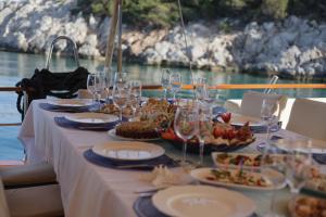 une table avec des verres et des assiettes de nourriture sur un bateau dans l'établissement Lüks gulette tekne tatili, à Bodrum City