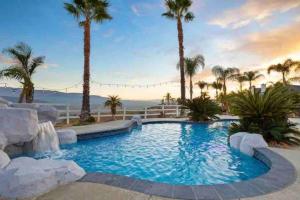 a swimming pool with palm trees in a resort at Grenache Estate - Nestled in Temecula Wine Country in Temecula