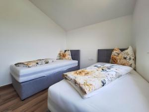 two beds in a room with white walls at Apartments KULAS in Novi Vinodolski