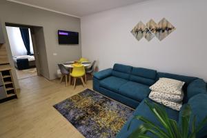 a living room with a blue couch and a table at Georgescu House in Făgăraş