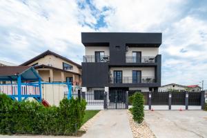 ein schwarzweißes Gebäude mit einem Zaun in der Unterkunft Casa Mathias in Eforie Nord