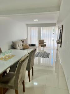 a dining room with a table and chairs and a couch at Apartamento luxuoso rua lazer in Domingos Martins