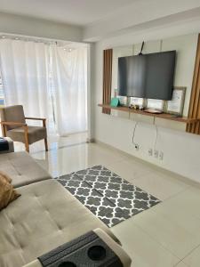 a living room with a couch and a flat screen tv at Apartamento luxuoso rua lazer in Domingos Martins