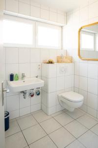 a white bathroom with a toilet and a sink at Blauwal - W14, Zentral in Bahnhofsnähe, Balkon, Küche in Ulm