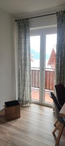 a living room with a large sliding glass door at Una Finestra sul Lago in Molveno
