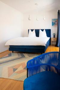 a bedroom with a bed and a blue chair at Blauwal - W14, Zentral in Bahnhofsnähe, Balkon, Küche in Ulm