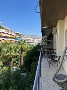 a balcony of a building with chairs and palm trees at Acropolis Sidewalk view in Athens