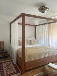 a bedroom with a wooden canopy bed with white curtains at Soko holiday home Bihac in Bihać +58 photos