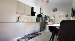 a white kitchen with a table and a refrigerator at Studio Sofia in Rakek