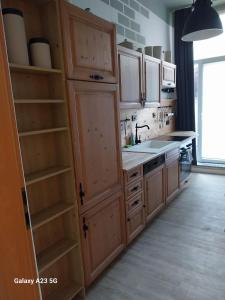 a kitchen with wooden cabinets and a sink at FeWo Bismarkstraße 32 - 3Raum in Stendal