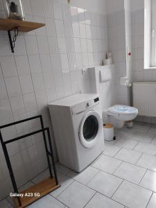 a bathroom with a washing machine and a toilet at FeWo Bismarkstraße 32 - 3Raum in Stendal