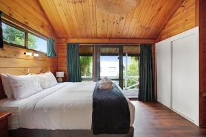 オークランドにあるGreenhithe Hidden Gem with Sea Views and Parkingの木製の天井の部屋にあるベッドのある寝室