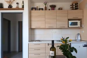 a kitchen with wooden cabinets and a bottle of wine at Ubytování Na Vinici in Valtice +12 photos