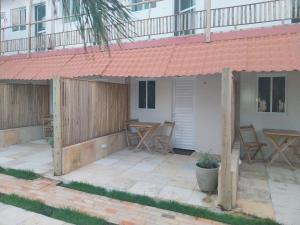 a patio with a table and chairs and a building at Jardim das Dunas in Canoa Quebrada