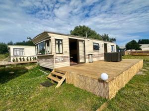 a tiny house with a deck and a porch at Domki i przyczepy Kemping Sunday Camp in Władysławowo