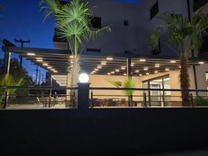 a night view of a building with tables and chairs at RADINA FAMILY in Kallithea Halkidikis