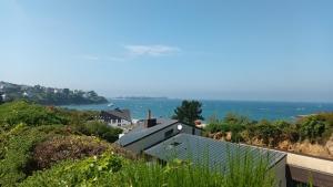 a house on a hill with the ocean in the background at Kelenn29 in Carantec