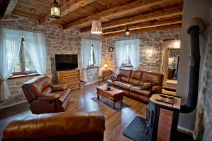 a living room with leather furniture and a fireplace at Villa Marijana in Zmijavci