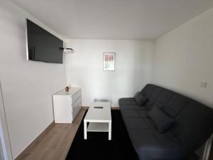 a living room with a couch and a table at Carol California in Chevigny-Saint-Sauveur