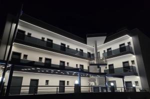 a large white building with a balcony at night at RADINA FAMILY in Kallithea Halkidikis +15 photos