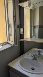 a bathroom with a white sink and a mirror at appartement rénové-équipé en centre-ville in Le Puy en Velay +5 photos