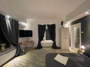 a bedroom with black curtains and a bed and a tv at Apartment Central very close to Aquapark Nymphaea in Oradea +45 photos