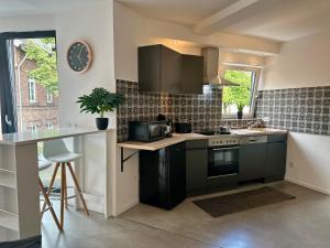 a kitchen with black cabinets and a counter top at Apartment MiRa 2 in Pulheim