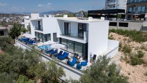 an external view of a house with chairs and tables at Luxury Villas Angela in Ksamil