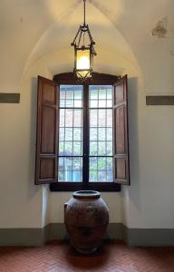 ピストイアにあるPalazzo Bracciolini Nel cuore della cittàの窓付きの部屋に大きな花瓶が置かれています。