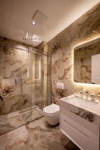 a bathroom with a shower and a toilet and a sink at Luxury Villas Angela in Ksamil