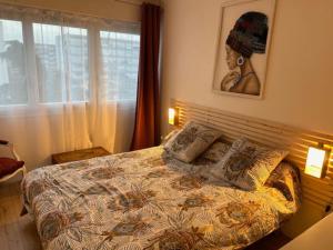 ein Schlafzimmer mit einem großen Bett mit geblümter Decke in der Unterkunft Bel appartement familial proche Versailles in Vélizy-Villacoublay