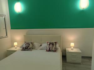 een slaapkamer met een groot wit bed en twee lampen bij La Pace in Savoca 