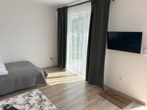 a bedroom with a bed and a large window at Domki Pasieka Domek C in Przeczyce