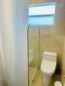 ein Bad mit einem weißen WC und einem Fenster in der Unterkunft Roosevelt Corner By The Ocean in Hollywood