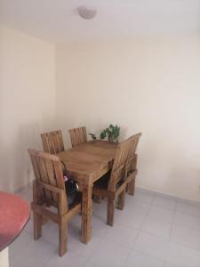 einem Holztisch mit zwei Stühlen und einer Pflanze darauf in der Unterkunft Casa Ixtapa in Ixtapa