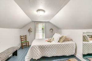 une chambre avec un lit blanc et une chaise dans l'établissement Family Fancy Gap Cottage with Deck - Pets Welcome!, à Fancy Gap