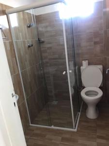 a bathroom with a glass shower with a toilet at Apartamento em condomínio, alugo para o ENCANTOS DO NATAL GARANHUNS in Garanhuns