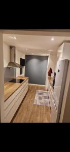 a large kitchen with white cabinets and a refrigerator at Nydelig leilighet til leie in Halden