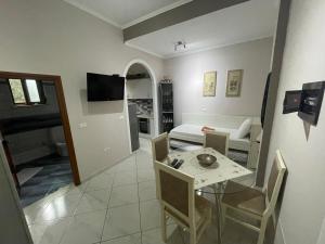a living room with a dining table and a living room at Edgar Hotel in Vlorë