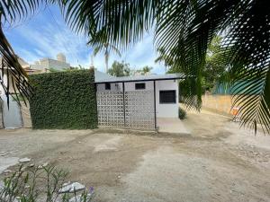 un bâtiment blanc avec une clôture à côté d'une haie dans l'établissement Villa Cocos #4, à San Francisco 26 autres photos