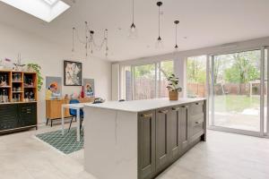 Una cocina con encimera blanca y algunas ventanas. en Charmante maison - Proche JO 2024, en Montigny-le-Bretonneux 18 fotos más