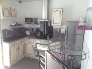 uma cozinha com uma mesa de vidro e um frigorífico em Studio indépendant dans villa avec piscine à Gap em Gap