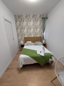 sypialnia z łóżkiem z zielonym kocem w obiekcie Habitaciones Universal w Madrycie