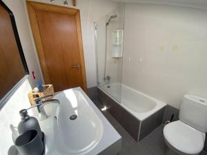 Un baño con lavabo, inodoro y ducha. en Ático de Ensueño- Tu Paraíso en Cantabria, en Beranga