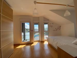 Un dormitorio con una cama y dos ventanas en Ático de Ensueño- Tu Paraíso en Cantabria, en Beranga