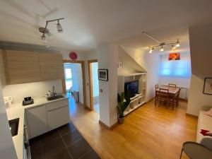 Una sala de estar con cocina y comedor. en Ático de Ensueño- Tu Paraíso en Cantabria, en Beranga