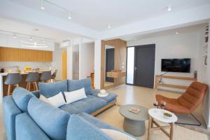 a living room with a blue couch and a kitchen at Aquamarina Villas in Lefkada Town